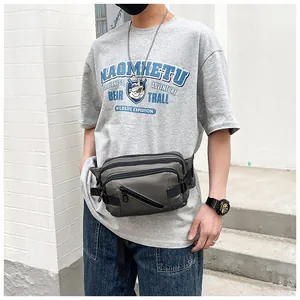 Detail of dark grey tactical chest bag with multiple zipper compartments and buckles