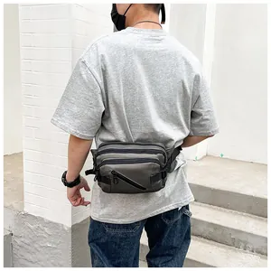 Detailed view of gray oxford fabric waist bag with adjustable strap in outdoor setting
