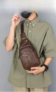 Detail view of brown vintage leather chest bag for men showing earphone hole and zippers