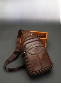 Brown leather chest bag with pebble texture and multiple zippers against vintage background