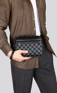 Modelo masculino con bolso bandolera de cuero a cuadros grises y estilo casual formal