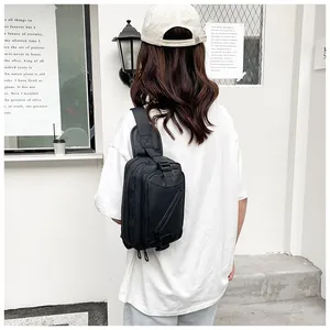 Close-up of black waterproof nylon crossbody chest bag with adjustable strap on a model