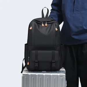 Moderner schwarzer Business-Rucksack mit orangefarbenen Akzenten auf silbernem Koffer