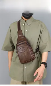 Brown vintage leather chest bag for men showing multi-layered zippers and logo detail