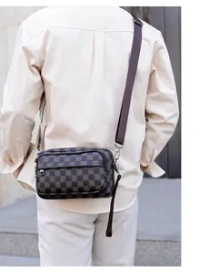 Détail du sac messager à damier avec bandoulière réglable porté par un mannequin dehors