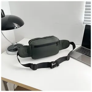 Detail of waterproof nylon waist bag in dark green featuring adjustable strap on white desk