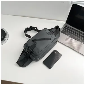 Detail of grey crossbody bag with heavy duty adjustable strap and secure buckle on desk