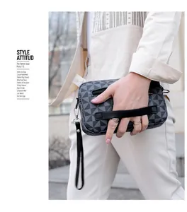 Détail du sac messager à carreaux avec poignée en cuir noir et motif géométrique