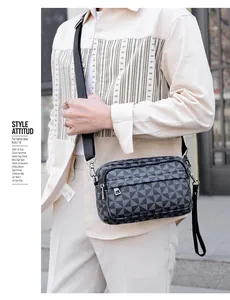 Détail d'un sac bandoulière pour homme avec motifs géométriques et doubles fermetures éclair