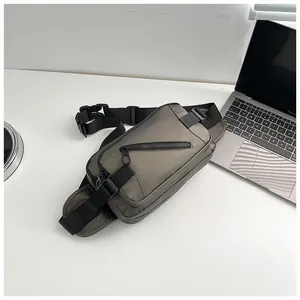 Detail view of water-resistant oxford fabric chest bag next to laptop on desk
