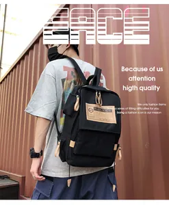 Detail of a black canvas backpack featuring vintage labels and beige leather zipper pulls