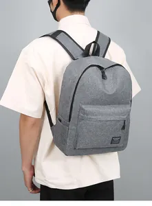 Zijaanzicht van een grijze minimalistische rugzak met verstelbare riemen op een model