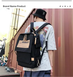 Detailed view of black canvas backpack with brown leather patch in urban street style setting