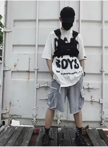 Look streetwear con camiseta blanca, pantalones cargo grises y bolsa táctica negra