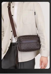 Close-up of brown monogram crossbody bag worn by model with adjustable strap