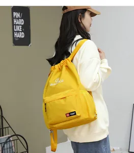 Dettaglio dello zaino giallo in tessuto Oxford con coulisse, zip frontale e tasche a rete