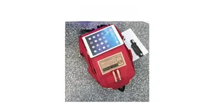 Detailed top view of red canvas backpack with dual zippers and tablet for size reference