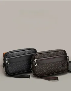 Detail of crossbody bag showing premium monogram texture in black and coffee leather
