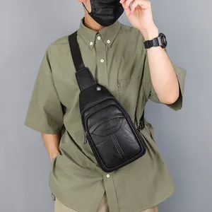 Men's black lychee texture leather sling bag with adjustable strap worn by model