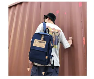 Close-up of durable navy canvas backpack featuring brand label and industrial background