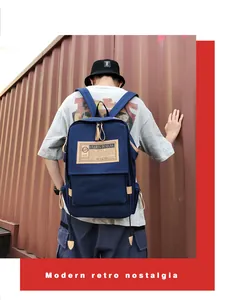 Rear view of deep blue canvas backpack on model with vintage leather accents