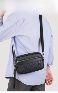 Men's black crossbody bag with logo pattern shown on model for fashion style