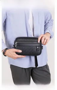 Close-up of men's black crossbody bag with jacquard brand texture and silver hardware