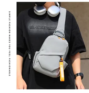 Détail du sac de poitrine gris avec sangle orange mode et fermeture éclair latérale