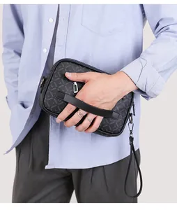 Detail of men's leather clutch bag with letter pattern and detachable wrist strap