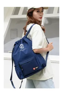 Detail view of large capacity navy drawstring bag with durable nylon and side mesh pocket