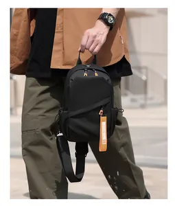 Détail du sac de poitrine noir en oxford avec sangle orange et poche zippée biais