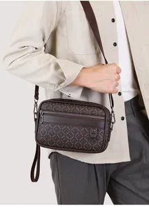 Side view of men's dark brown crossbody bag with logo print on a male model