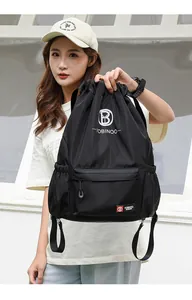 Close-up of black drawstring backpack featuring high-quality nylon fabric and zipper pocket
