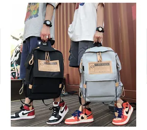 Close-up of black and blue canvas backpacks with leather labels and dual zippers