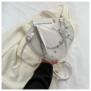 Detail of white heart-shaped PU crossbody bag with silver chains and rivets
