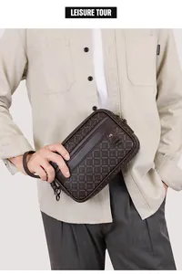 Detail of a dark brown leather clutch with letter patterns and metal zipper