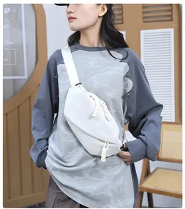 Close-up of a white minimalist nylon crossbody bag featuring stylish thick rope zippers