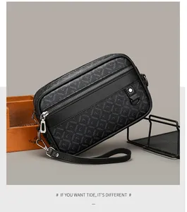 Detail of black leather men's messenger bag with logo pattern and metallic zippers