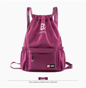 Détail du sac à dos violet foncé avec cordon de serrage et poche frontale zippée
