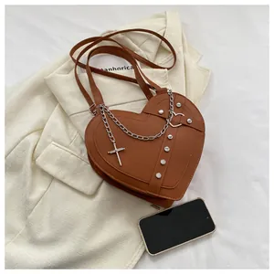 Detailed view of heart-shaped brown PU leather bag with silver chain and rivet accents