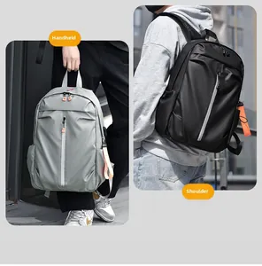 Détail du sac à dos en nylon gris et noir montrant le port à la main et à l'épaule