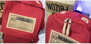 Detail of durable red canvas backpack with vintage logo patch and metal zippers