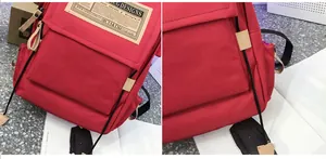Detail of red canvas backpack featuring vintage woven label and leather zipper pulls