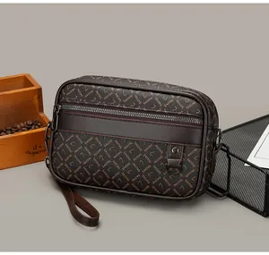 Detail of dark brown crossbody bag with letter pattern and metal front zipper