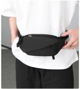 Close-up of minimalist black waist bag with matte nylon fabric and unique folding design