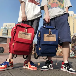 Red and navy blue large canvas travel backpacks for men and women in street style
