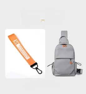 Detail view of gray Oxford fabric chest bag with vibrant orange decorative charm