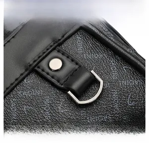Detail shot of black leather texture with SAOINI logo embossing and silver metal D-ring