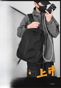Detail of waterproof black backpack showing the built-in external USB charging port feature