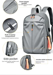 Vue détaillée du sac à dos gris avec port USB, compartiment PC et fermetures orange